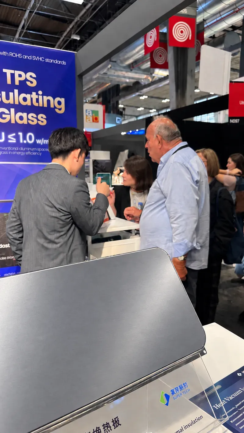 Visitors discussing vacuum insulation samples with the Supertech team at BATIMAT 2026