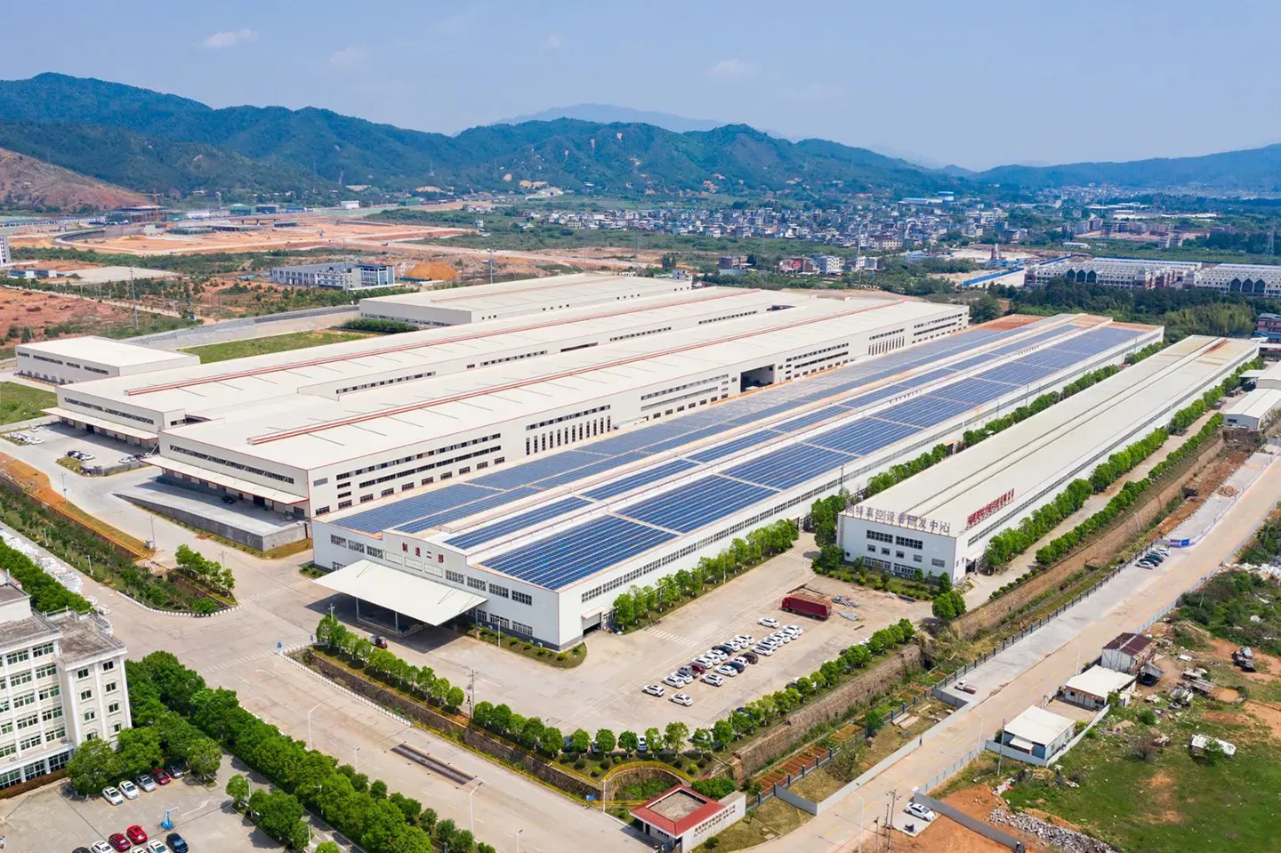 Vista aérea del campus de fabricación de aislamiento al vacío de Super Tech en Longyan, Fujian, con paneles solares en los techos de las naves