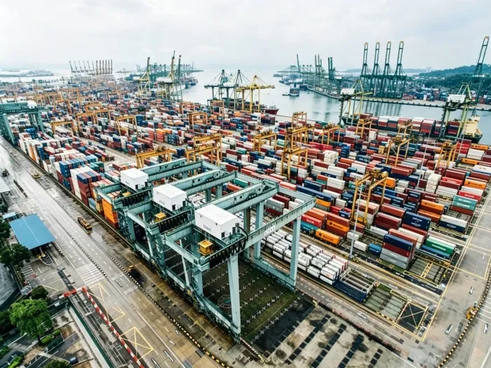 Container terminal photograph reproduced from the group source article. Transport dimensions are a design input, not evidence of a certified building project.